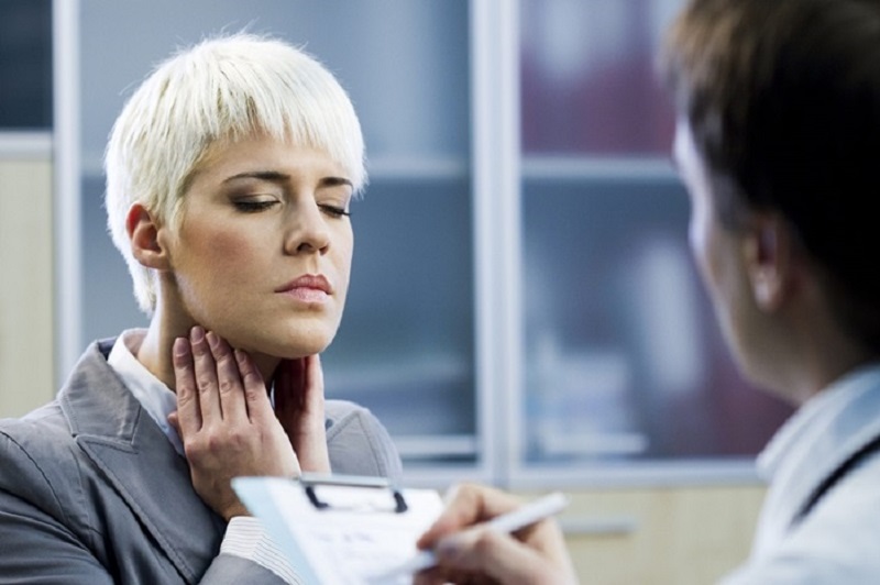 Woman holding her throat